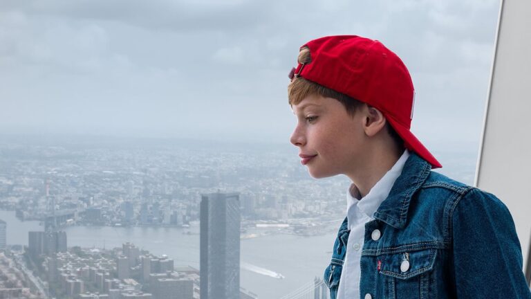 Visitante observa Lower Manhattan e o East River pelas janelas do One World Observatory